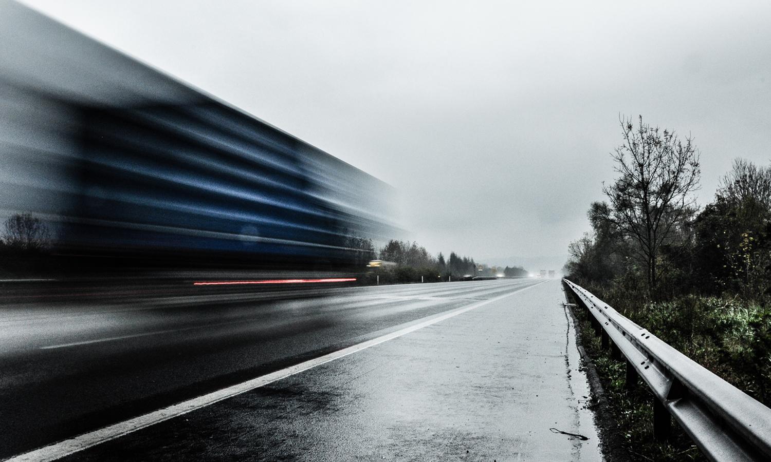 A truck moving fast on a highway.