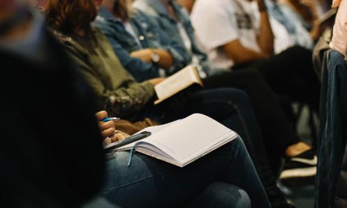 Person taking notes during a meeting.