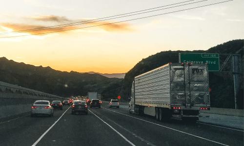 Heavy duty trucks and smaller cars stuck in traffic.