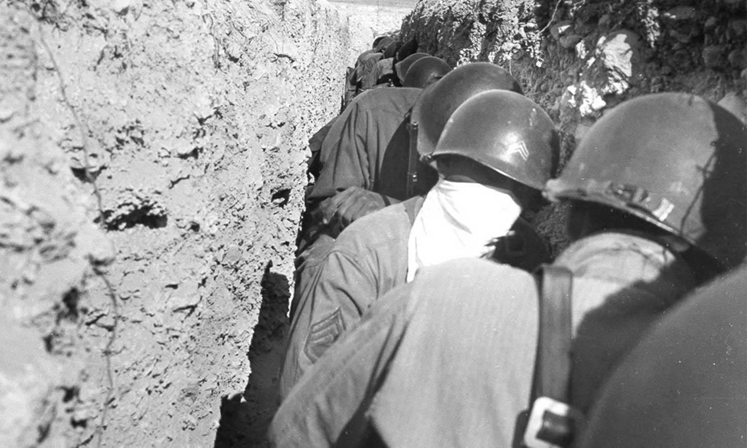 Atomic troops crouching in trench 