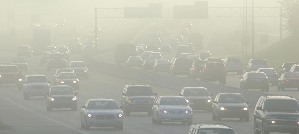 Cars in a haze on a highway.